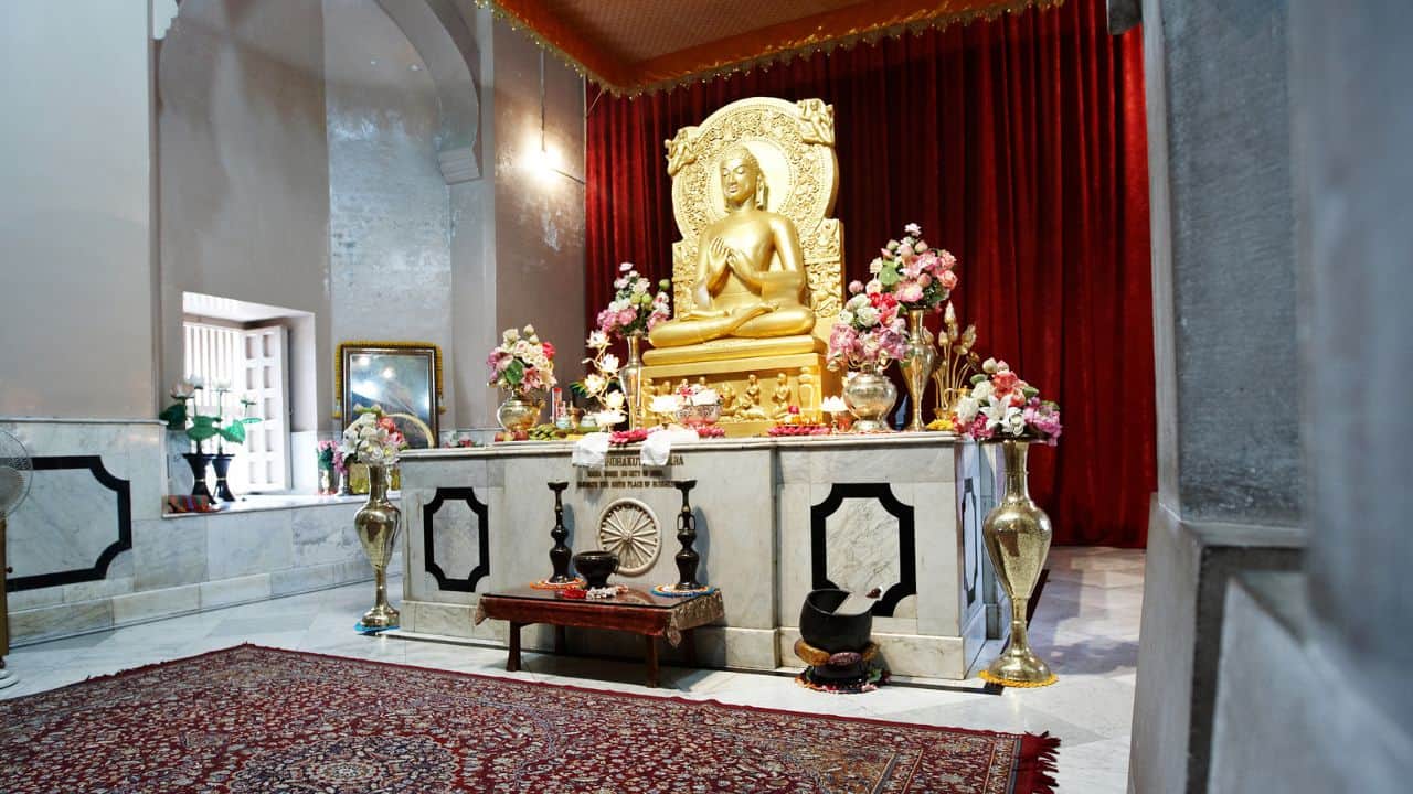 A-Buddha-statue-is-positioned-in-a-room-with-red-curtains-capturing-the-spiritual-essence-of-Varanasi-India.jpg