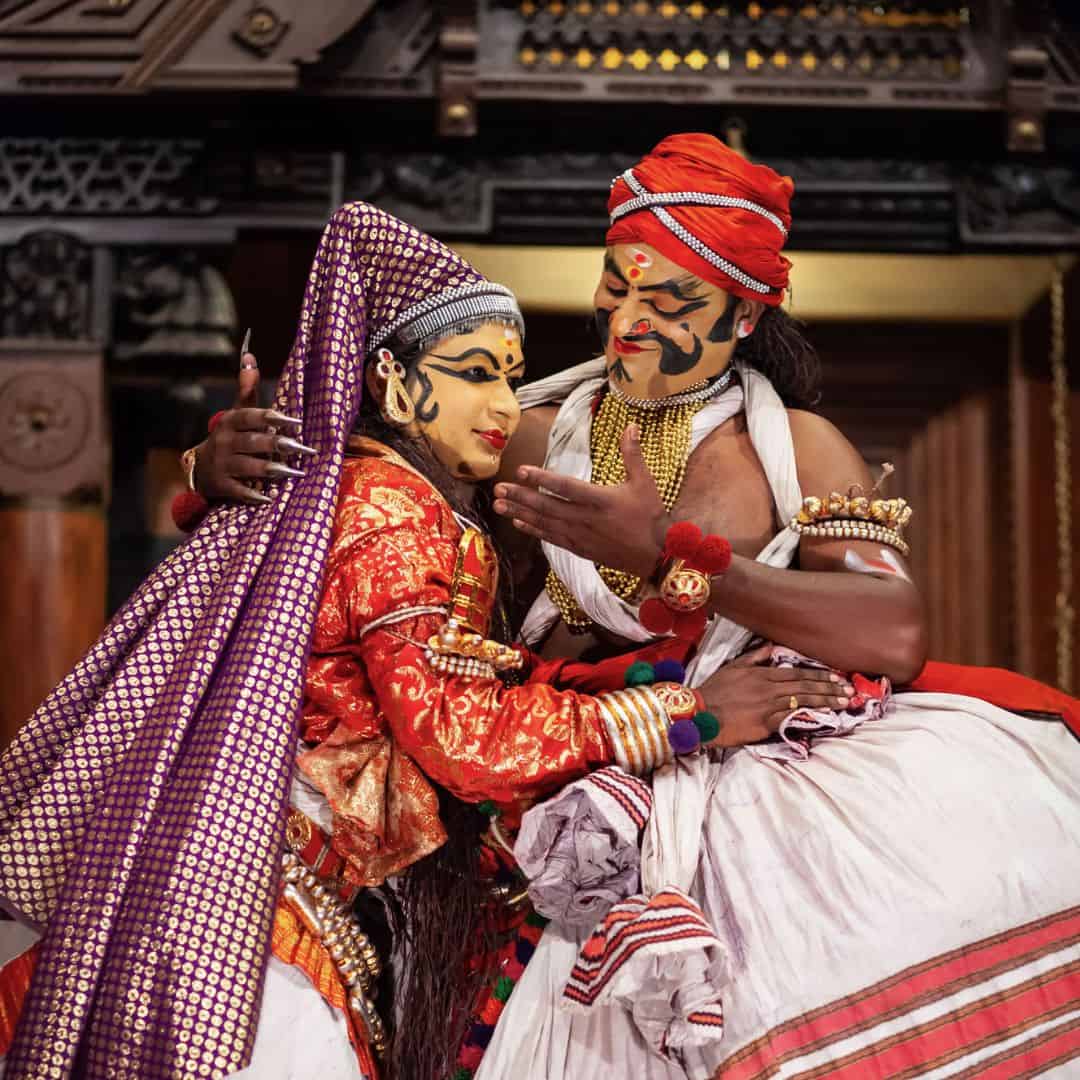 A Kathakali dance performance featuring two dancers in vibrant traditional costumes A Kathakali dance performance featuring two dancers in vibrant traditional costumes