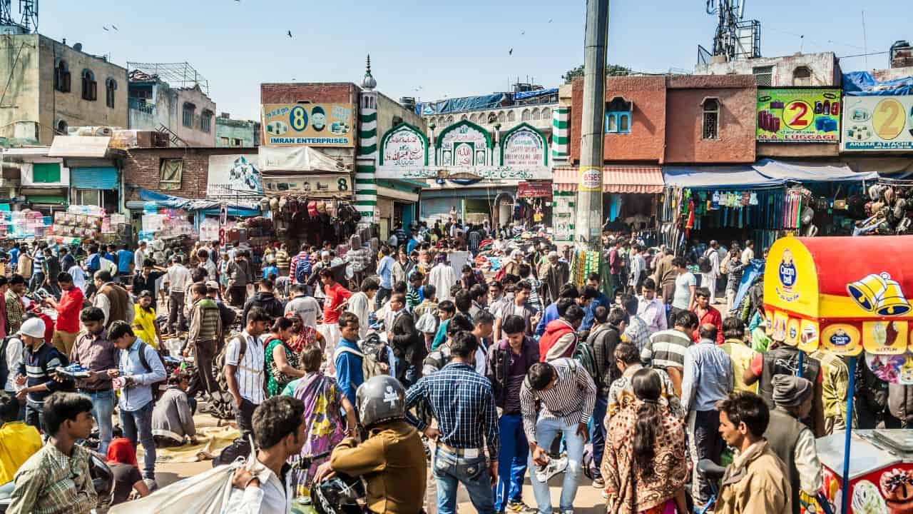A-bustling-market-in-Old-Delhi-filled-with-people-walking-among-colorful-stalls-and-vibrant-displays.jpg