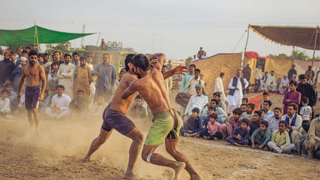 A-crowd-watches-as-two-men-compete-in-a-sand-wrestling-match-showcasing-the-traditional-Kushti-of-Varanasi.jpg