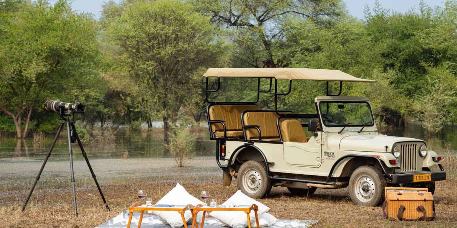 A-jeep-beside-a-picnic-table-and-tent-on-grassy-land-showcasing-the-natural-beauty-of-Rajasthan-India.jpg