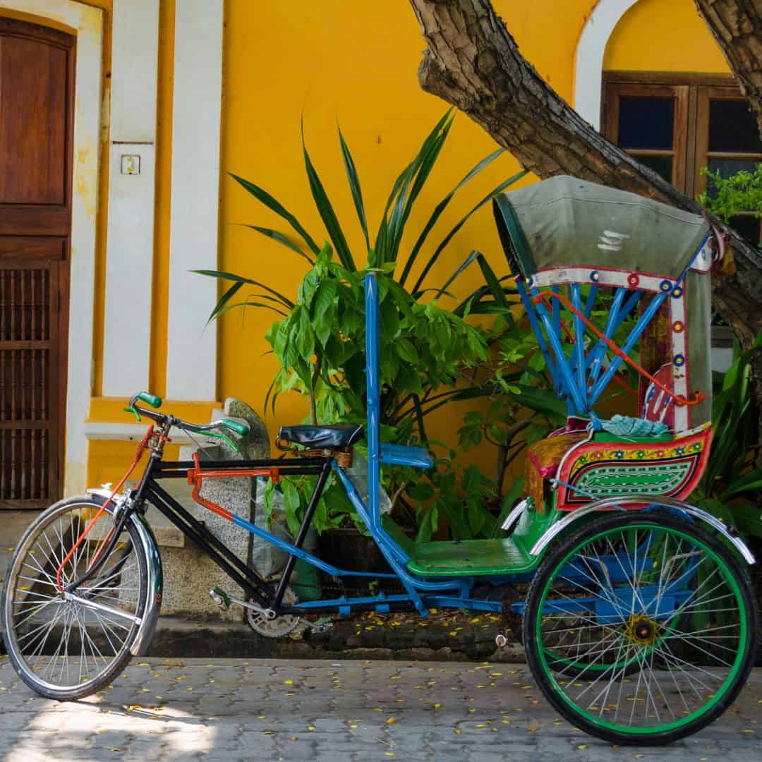 A lively rickshaw is parked outside a yellow building, capturing the essence of Pondicherry's streets A Rickshow is parked outside a yellow building capturing the essence of Pondicherrys streets