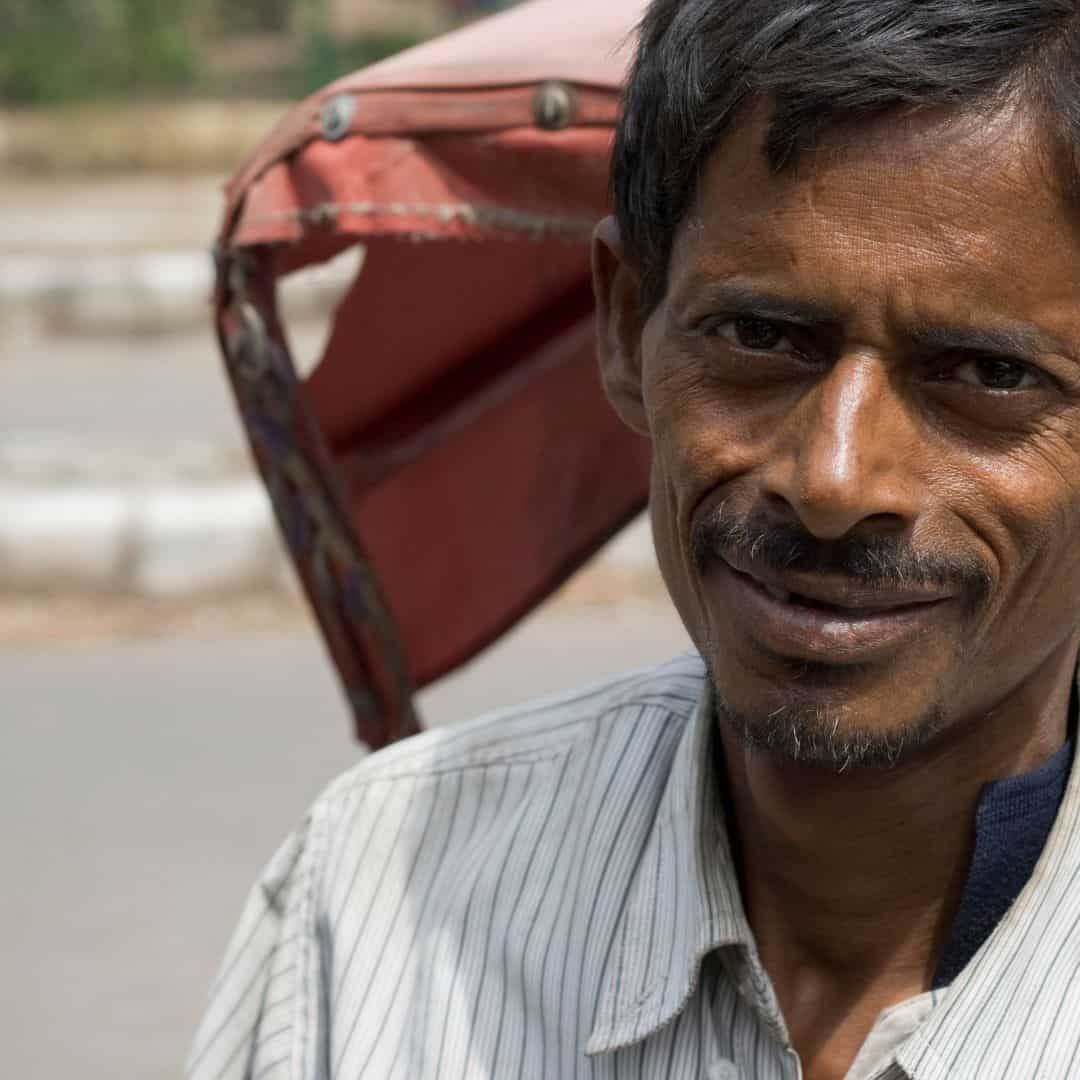 A man smiles while sitting on a rickshaw during an Old Delhi ride, showcasing the vibrant local culture A man smiles while sitting on a rickshaw during an Old Delhi ride showcasing the vibrant local culture