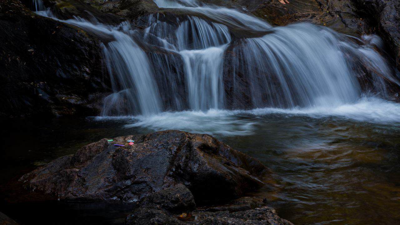 A-picturesque-waterfall-flows-over-rocks-in-Munnar-India-enhancing-the-beauty-of-the-river-and-its-lush-environment.jpg
