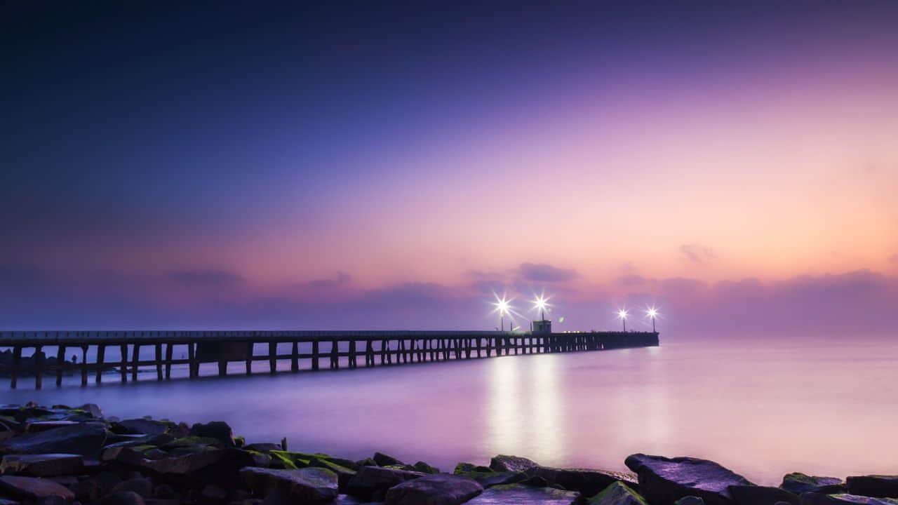 A-scenic-view-of-a-long-pier-illuminated-by-lights-at-its-end-located-in-Pondicherry.jpg