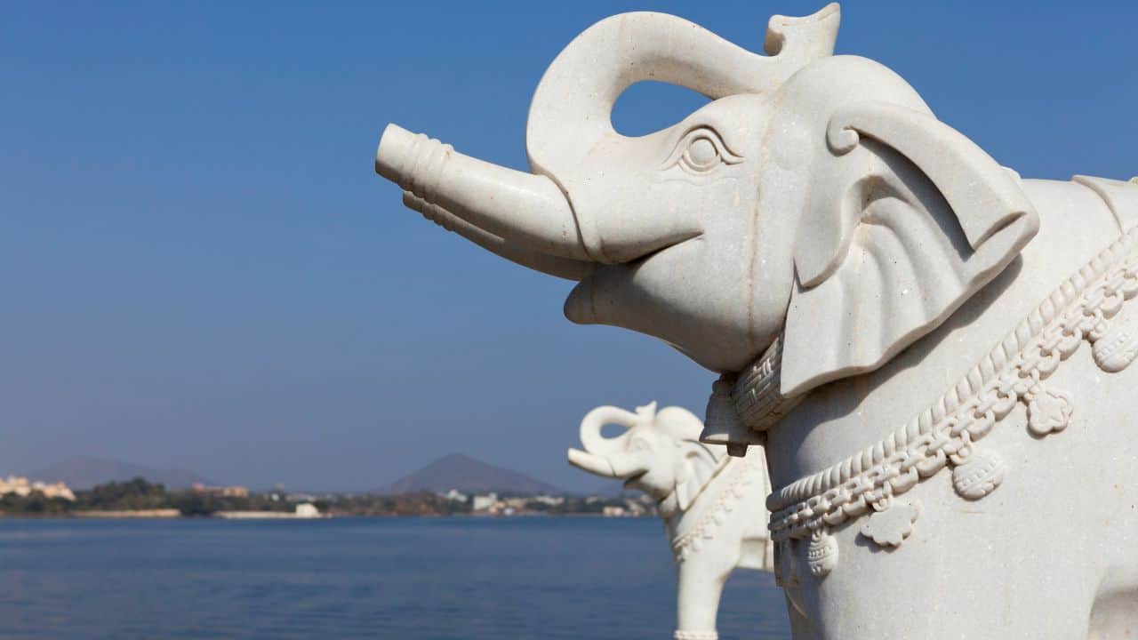 A-statue-of-an-elephant-stands-beside-a-tranquil-body-of-water-at-Jag-Mandir-India.jpg