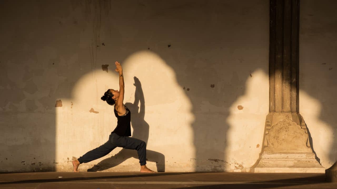 A-woman-performs-yoga-poses-in-front-of-a-wall.jpg