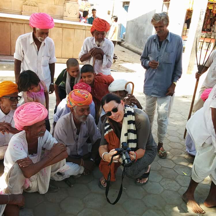 A woman takes a picture of a group of people at Chanoud Garh, India A woman takes a picture of a group of people at Chanoud Garh, India