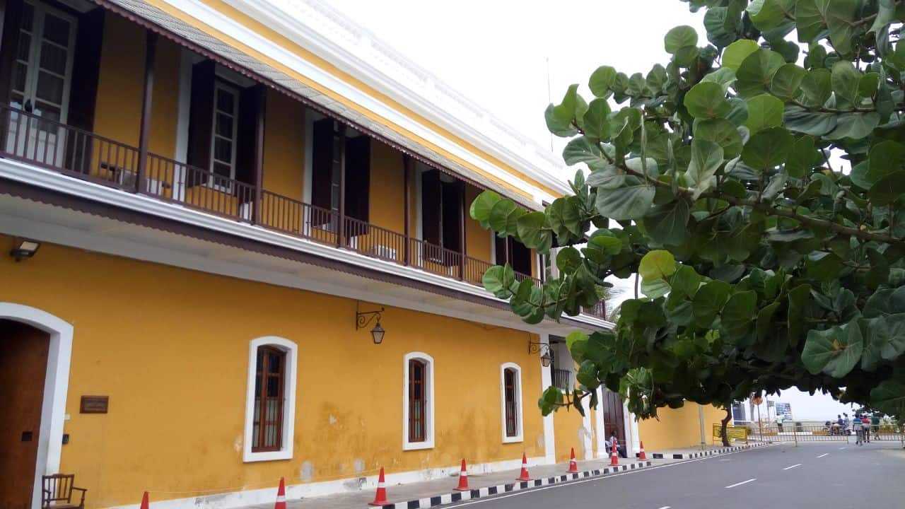 A-yellow-building-with-a-tree-in-front-located-in-Pondicherry-showcasing-vibrant-architecture-and-greenery.jpg