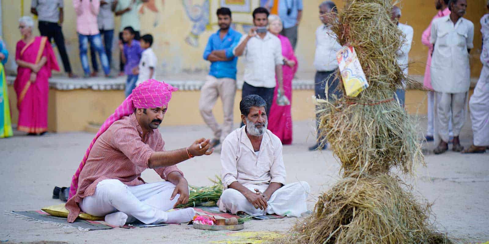 In-Chanoud-Garh-India-a-man-wearing-a-turban-sits-on-the-ground-with-several-other-individuals-nearby.jpg