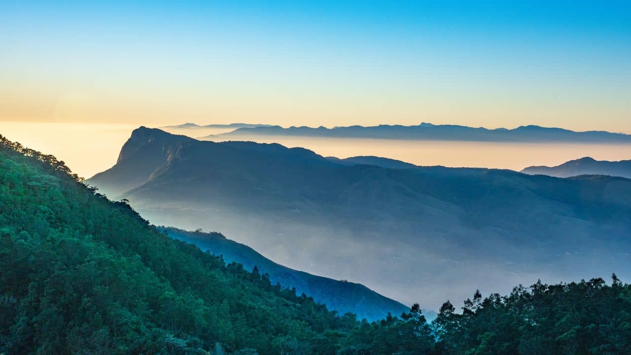 Sunrise-view-from-a-mountain-peak-showcasing-the-lush-tea-plantations-of-Munnar-during-the-Tea-Heritage-Tour.jpg