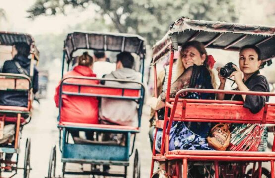 Tourists-experiencing-a-vibrant-rickshaw-ride-in-Old-Delhi-surrounded-by-colorful-street-scenes-555x360.jpg