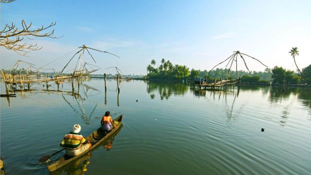 Two-people-in-a-boat-on-the-water-with-a-net-set-in-Muziris-India.jpg