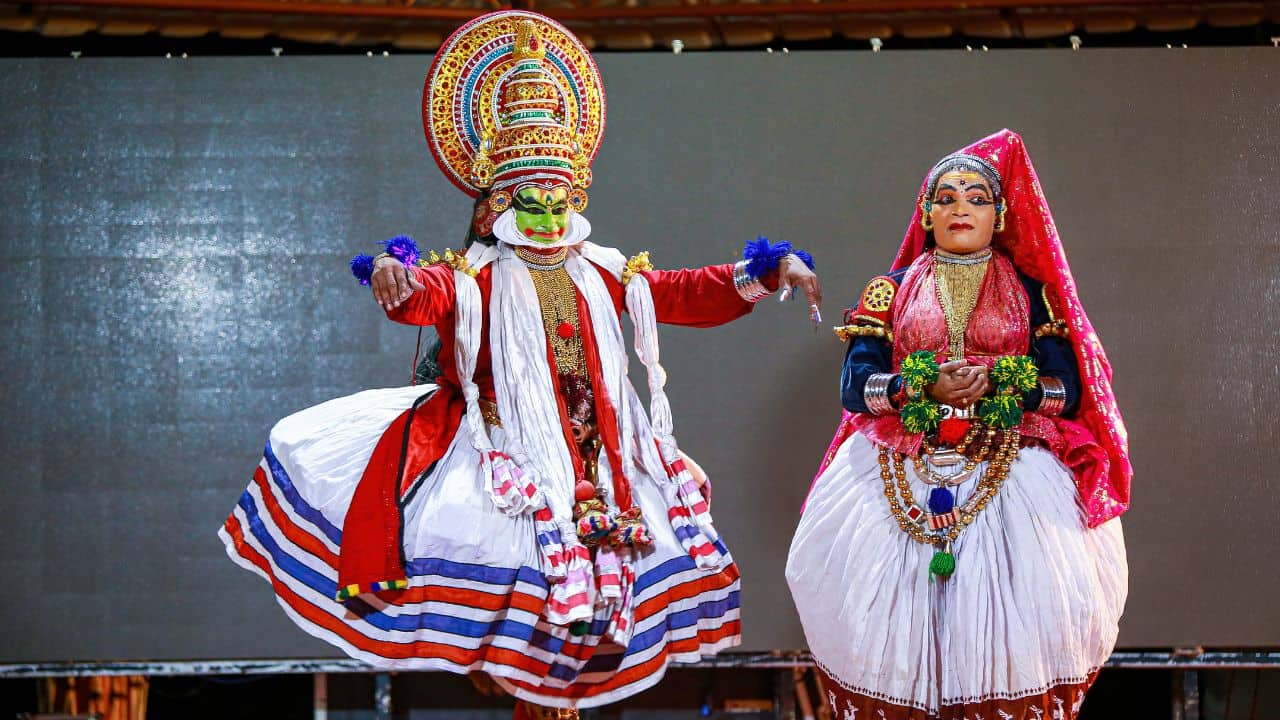 Two-performers-in-traditional-Kathakali-costumes-dance-expressively-during-a-cultural-performance-in-India.jpg