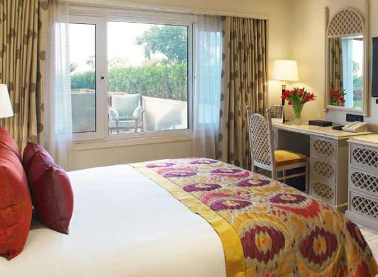 A-modest-hotel-room-in-India-featuring-a-bed-desk-and-window-showcasing-simple-yet-comfortable-accommodation-750x550.jpg
