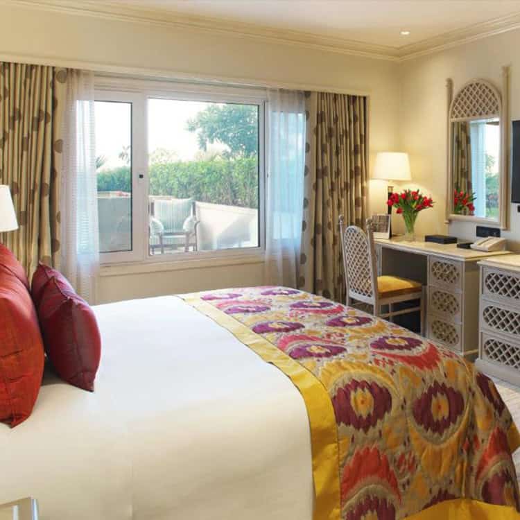 A-modest-hotel-room-in-India-featuring-a-bed-desk-and-window-showcasing-simple-yet-comfortable-accommodation.jpg
