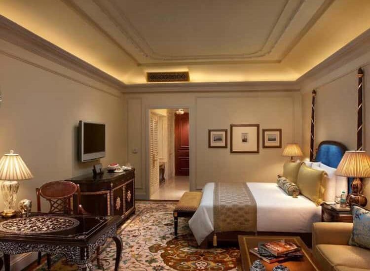 A-spacious-hotel-room-featuring-a-plush-bed-desk-and-chair-showcasing-luxurious-Indian-accommodation-750x550.jpg