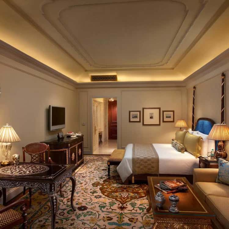 A-spacious-hotel-room-featuring-a-plush-bed-desk-and-chair-showcasing-luxurious-Indian-accommodation.jpg