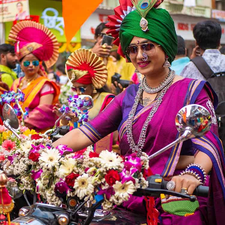 A woman in vibrant traditional attire riding a motorcycle on a road in India, showcasing cultural expression and freedom A woman in vibrant traditional attire riding a motorcycle on a road in India showcasing cultural expression and freedom